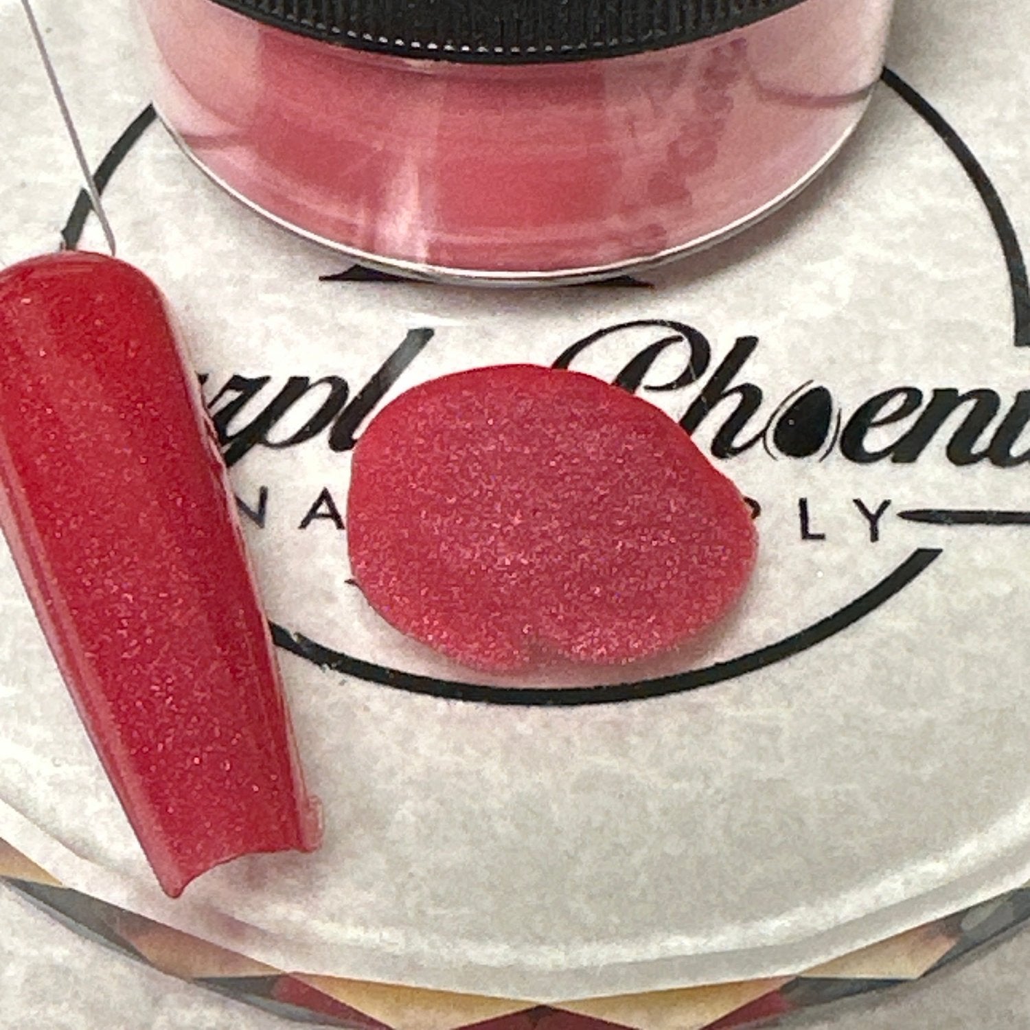 Close-up of Blushing Berry Acrylic Powder - a gentle berry pink with a subtle shimmer, applied on a nail tip, highlighting its sweet and elegant appearance.