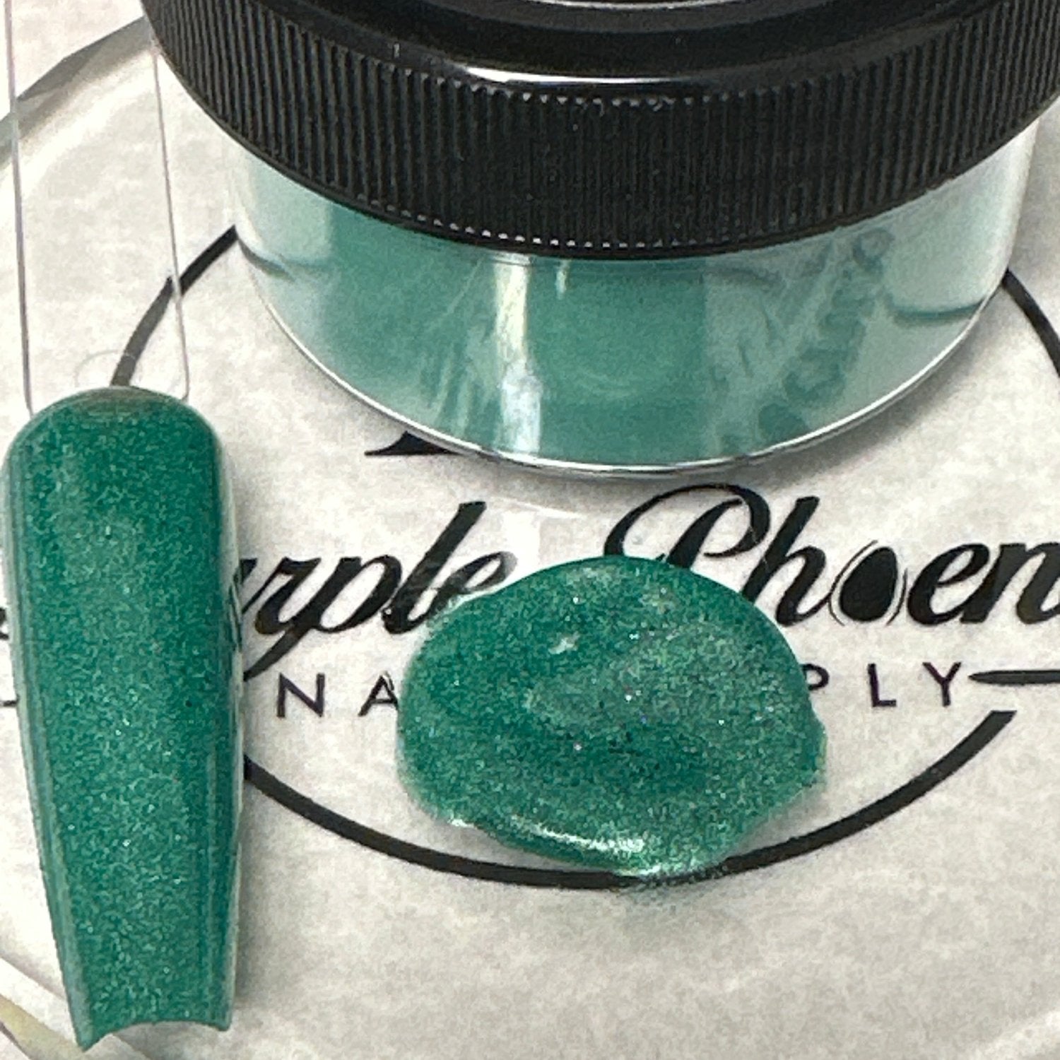 Close-up of Emerald Lagoon Acrylic Powder - teal with a subtle shimmer, applied on a nail tip, highlighting its captivating, oceanic appearance