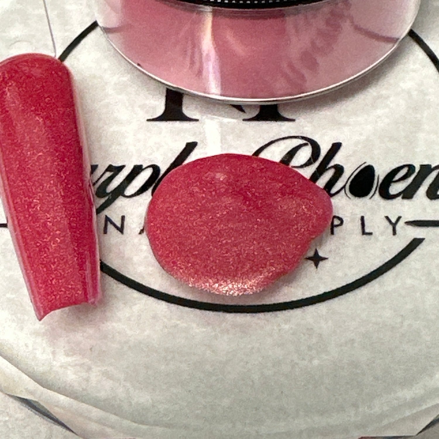 Close-up of Strawberry Fizz Acrylic Powder - lively pink with subtle glitter, applied on a nail tip, highlighting its fun, sparkling appearance.