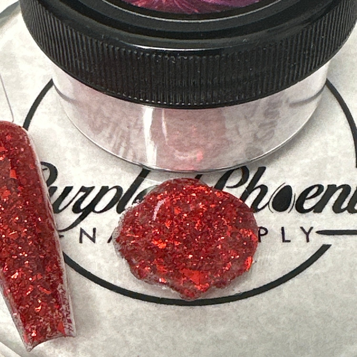 Close-up of Vampire's Desire Acrylic Powder - deep red with bold glitter accents, applied on a nail tip, highlighting its mysterious and alluring appearance.