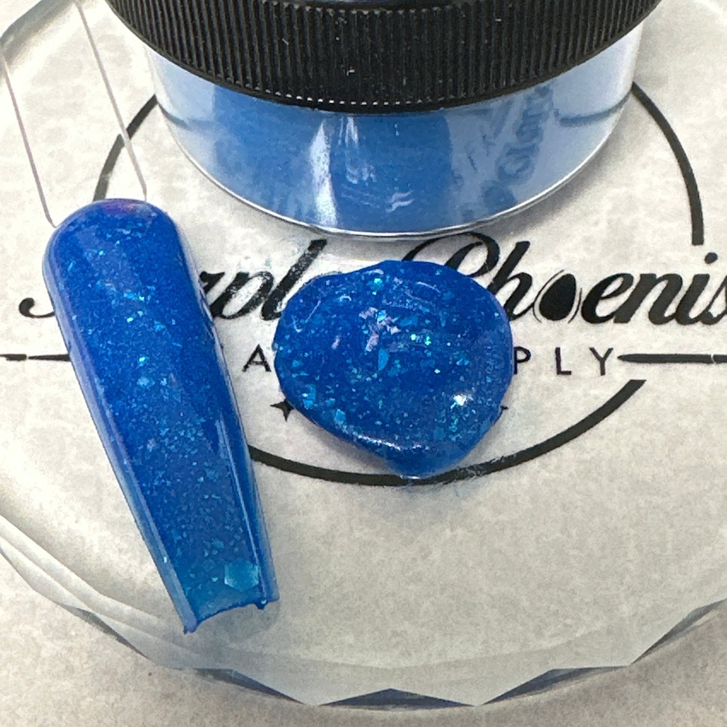 Swatch of Crystal Tide Acrylic Powder - a shimmering, translucent powder with subtle iridescence, applied on a nail tip, showcasing its sparkling, ocean-inspired finish.