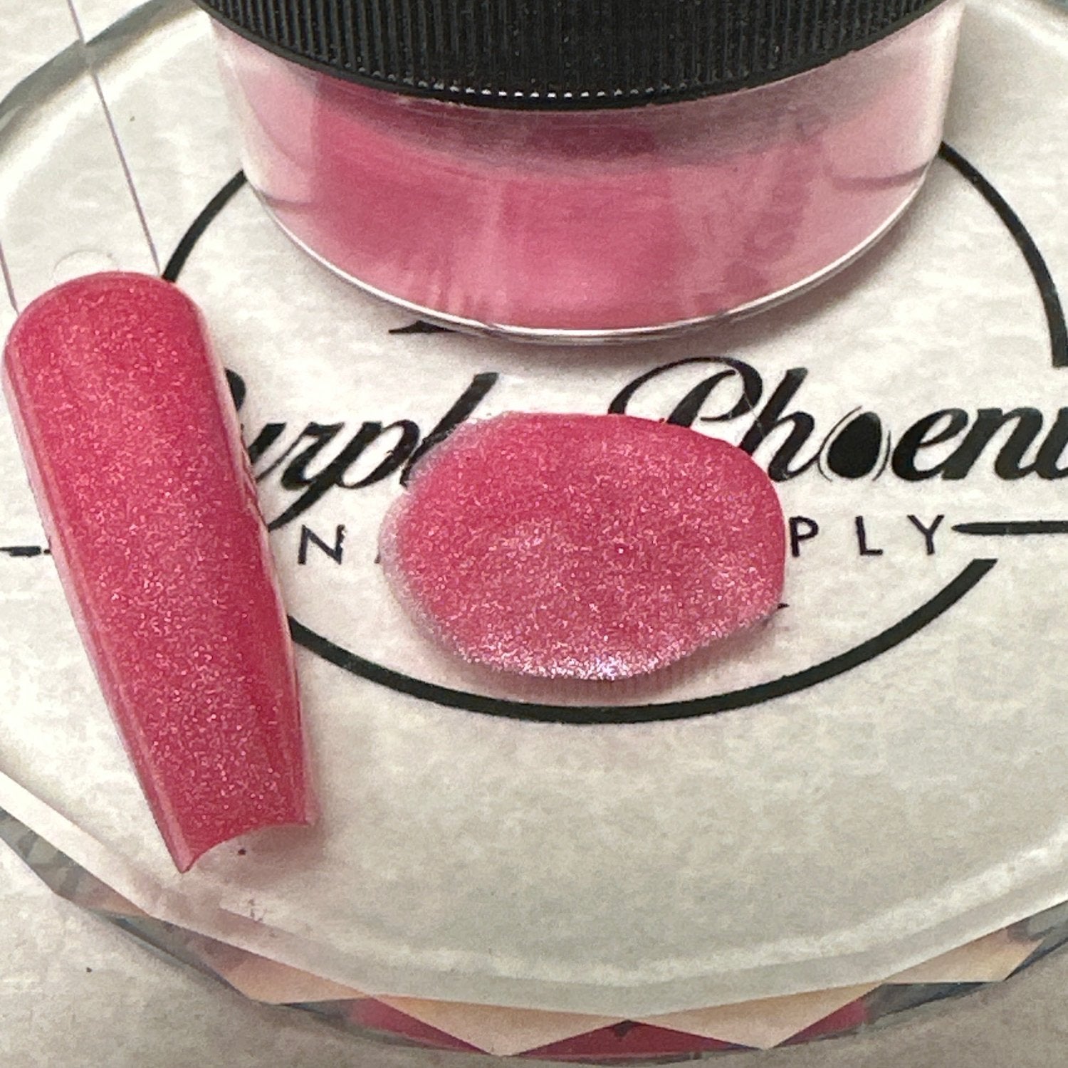 Swatch of Hibiscus Blush Acrylic Powder - a vibrant pink shade with a subtle shimmer, applied on a nail tip, showcasing its bold and tropical finish