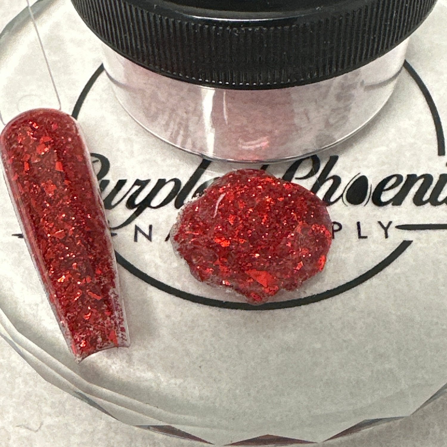 Swatch of Vampire's Desire Acrylic Powder - a dark red shade with striking red glitter, applied on a nail tip, showcasing its bold and dramatic finish